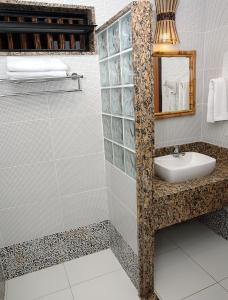 W łazience znajduje się umywalka i lustro. w obiekcie Pousada Ogum Marinho w mieście Praia do Forte