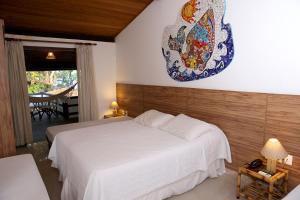 sypialnia z łóżkiem i talerzem na ścianie w obiekcie Pousada Ogum Marinho w mieście Praia do Forte