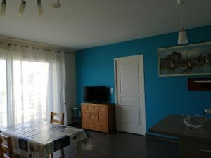 a dining room with a table and a blue wall at villa marine 2 in Jullouville-les-Pins