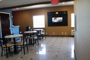 a dining room with tables and chairs and a tv on the wall at Magnolia Inn and Suites Southaven in Southaven