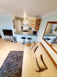 a living room with a couch and a kitchen at Chelmsford Town Centre Apartments With Car Parking in Chelmsford