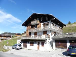 a building with a balcony on the side of it at PASTORALE 2 - Bel appartement avec terrasse - Wifi - Garage in La Clusaz