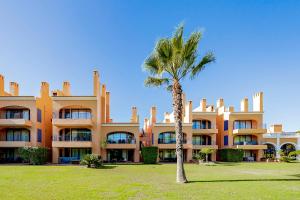 a palm tree in front of a large building at AL - Apartamento Vila Sol F5 Top Floor in Quarteira