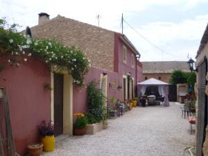 un callejón con casas rosas y una tienda con flores en Casa Rural Ubeda Pinoso-Alicante, en Úbeda