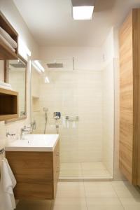 uma casa de banho com um lavatório e um chuveiro em Főtér Rezidencia em Gyor