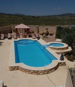 una piscina en un patio con sillas y mesa en Casa Rural Ubeda Pinoso-Alicante, en Úbeda