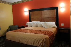 a hotel room with a large bed with red walls at Magnolia Inn and Suites Southaven in Southaven