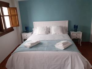 ein großes Bett mit zwei Kissen darüber in der Unterkunft La Calleja del Canchal in Arenas de San Pedro