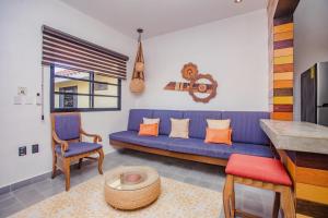 ein Wohnzimmer mit einem blauen Sofa und einem Tisch in der Unterkunft Condominio Sac Ki in Cozumel