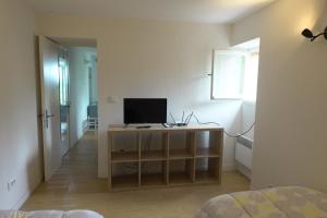 1 dormitorio con escritorio y TV. en Le Cigalon en Grasse