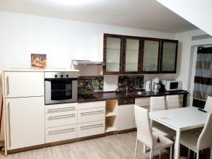 a kitchen with white cabinets and a table with chairs at Kempf Apartments in Rust