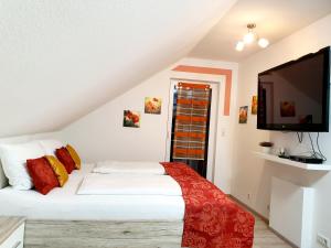 a bedroom with a bed and a flat screen tv at Kempf Apartments in Rust