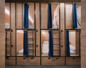 a row of bunk beds in a room with blue curtains at Campus Community A-Hotel in Kyiv