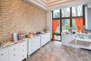 a kitchen with white cabinets and a brick wall at Haus Hohenstein in Witten