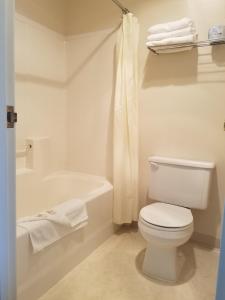 uma casa de banho branca com um WC e uma banheira em Butch Cassidy's Hideout em Circleville