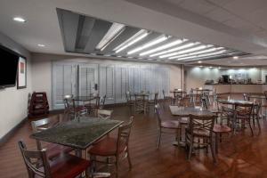 a restaurant with tables and chairs in a room at Wingate by Wyndham Oklahoma City Airport in Oklahoma City
