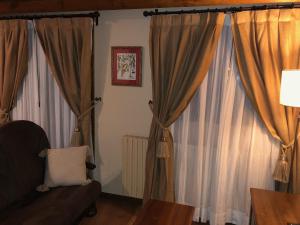 un soggiorno con tende e divano di Apartamentos Turisticos Lavedan a Tramacastilla de Tena
