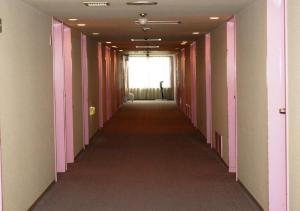 a long hallway with pink and white walls and a window at skyhotel uozu / Vacation STAY 59581 in Uozu