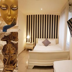 a bedroom with a bed with a gold face on the wall at Central Hotel in Tel Aviv