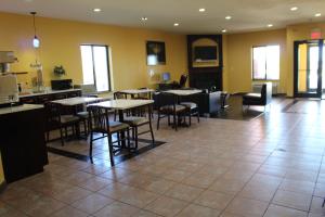 a restaurant with tables and chairs in a room at Home Gate Inn & Suites in Southaven