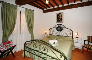 1 dormitorio con 1 cama con colcha verde en B&B Camere La Vite, en Pienza
