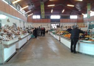 un gruppo di persone in un mercato con frutta e verdura di Edificio Lavadeiras a Olhão
