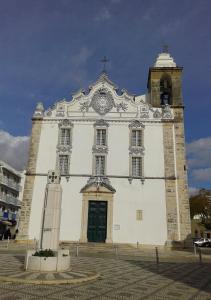 een grote witte kerk met een klok erop bij Edificio Lavadeiras in Olhão