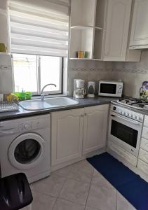 a kitchen with a sink and a washing machine at Edificio Lavadeiras in Olhão