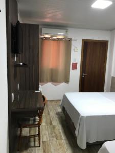 sypialnia z łóżkiem, biurkiem i oknem w obiekcie Hotel Alegrete w mieście Alegrete