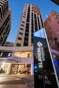 a hotel sign in front of a tall building at Slaviero São Paulo Moema in Sao Paulo