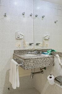 a bathroom with a sink and a mirror at Slaviero São Paulo Moema in Sao Paulo