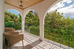 een patio met stoelen en een balkon bij Villa Amelia in Caniço