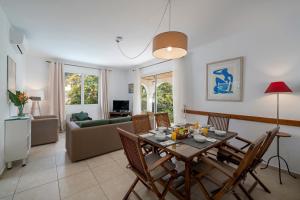 Una sala de estar con una mesa y sillas y un sofá. en Villa Amelia, en Caniço