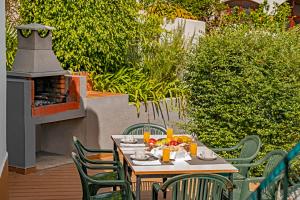 a table and chairs on a patio with a fireplace at Villa Amelia in Caniço