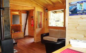 sala de estar con silla y boca de incendios en Posada de Expediciones Kahuel, en Chaitén