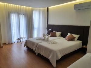 1 dormitorio con 1 cama grande con sábanas blancas en Residencial Dom Manuel, en Fafe