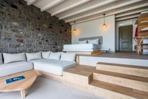 a living room with a couch and a brick wall at Hotel Milos Sea Resort in Adamantas