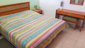 łóżko z kolorowym kocem i biurkiem w obiekcie Playa de la Arena Apartment w mieście Puerto de Santiago +36 zdjęć