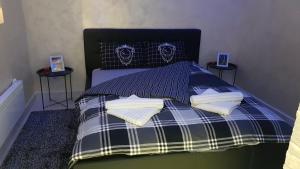 a bed with blue and white sheets and pillows at Apartmani Venera in Belgrade