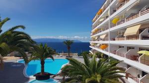 widok na hotel z basenem i ocean w obiekcie Playa de la Arena Apartment w mieście Puerto de Santiago