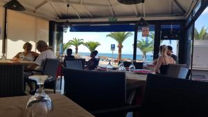 grupa ludzi siedzących przy stolikach na plaży w obiekcie Playa de la Arena Apartment w mieście Puerto de Santiago