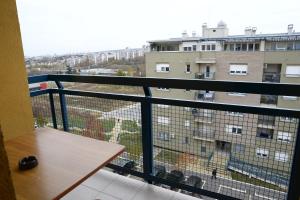 uma varanda com uma mesa e vista para um edifício em Zap apartman em Belgrado