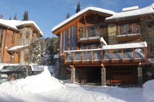 una casa con nieve en el suelo delante de ella en Woodhaven # 8 in Sun Peaks en Sun Peaks