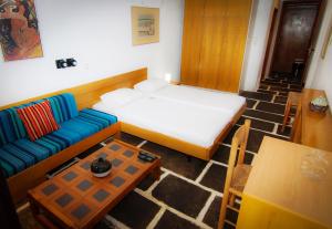 a room with a bed and a couch and a table at Apollonia Hotel Apartments in Varkiza