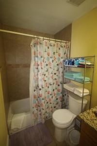 a bathroom with a toilet and a shower curtain at 1/1 bed&bath condos 5 min drive to Siesta in Sarasota