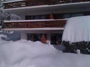 a house covered in snow with a pile of snow at Grain d'Or - Studio 008 in Verbier +4 photos