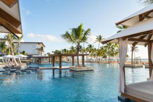 a pool at a resort with chairs and umbrellas at Hyatt Zilara Cap Cana - Adults Only in Punta Cana
