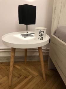 a small white table with a cup on top of it at Vinyl’s Place in Braşov