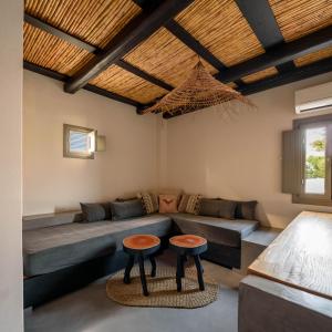 sala de estar con sofá y 2 taburetes en Misteli Suites, en Akrotiri