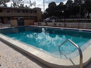 a swimming pool with blue water in front of a building at Budget Lodge Mount Dora in Mount Dora